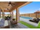 Staged patio with an outdoor kitchen, seating area, and a refreshing swimming pool at 1712 E Joelle Dr, Casa Grande, AZ 85122