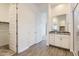 Contemporary bathroom featuring tiled floors, granite countertop vanity, and a walk-in closet at 17557 W Victory St, Goodyear, AZ 85338