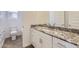 Well-lit bathroom with granite counters, white cabinets and sink, exuding modern elegance at 17557 W Victory St, Goodyear, AZ 85338