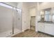 Modern bathroom showcasing a glass-enclosed shower, walk-in closet, and granite countertop vanity at 17557 W Victory St, Goodyear, AZ 85338