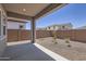 Covered patio overlooking a spacious backyard with desert landscaping and a tall brick fence at 17557 W Victory St, Goodyear, AZ 85338