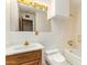 A well lit bathroom with a wood cabinet under the sink, and a toilet at 1810 N 74Th St, Scottsdale, AZ 85257