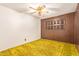 Cozy bedroom features retro yellow carpet, wood paneling, ceiling fan, and shutters at 1810 N 74Th St, Scottsdale, AZ 85257