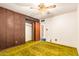 The bedroom has retro green carpet, ceiling fan, brick accents, and closet at 1810 N 74Th St, Scottsdale, AZ 85257