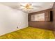 Cozy bedroom features retro yellow carpet, wood paneling, ceiling fan, and open shutters at 1810 N 74Th St, Scottsdale, AZ 85257