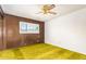 Bedroom features retro yellow carpet, wood paneling, and a sliding window at 1810 N 74Th St, Scottsdale, AZ 85257