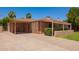 Single-Gathering home with attached carport and desert landscaping on a sunny day at 1810 N 74Th St, Scottsdale, AZ 85257