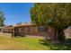 Well-maintained home with mature trees and partial brick exterior, set on a green lawn at 1810 N 74Th St, Scottsdale, AZ 85257