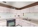 This retro kitchen features pastel cabinets, marbled countertops, wood paneling and a stainless steel sink at 1810 N 74Th St, Scottsdale, AZ 85257