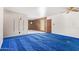Spacious living room with blue carpet, wood paneling, and a unique light fixture at 1810 N 74Th St, Scottsdale, AZ 85257