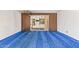 Spacious living room with blue carpet, wood paneling, and sliding glass doors to backyard at 1810 N 74Th St, Scottsdale, AZ 85257