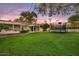Large backyard boasts a sprawling lawn, a refreshing pool, and a trampoline, great for recreation at 1831 E Rovey Ave, Phoenix, AZ 85016