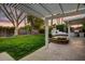 Expansive backyard with lush green lawn, a pergola, and an outdoor kitchen, ideal for relaxation at 1831 E Rovey Ave, Phoenix, AZ 85016