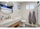 Cozy bathroom featuring updated vanity, round mirror, and blue tile accents at 1831 E Rovey Ave, Phoenix, AZ 85016