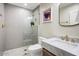 Stylish bathroom featuring a white tiled shower, marble sink, and gold fixtures at 1831 E Rovey Ave, Phoenix, AZ 85016