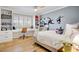 Bright bedroom featuring a built-in desk, shelving, and light hardwood floors at 1831 E Rovey Ave, Phoenix, AZ 85016