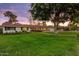 Landscaped front yard with green lawn, mature trees, and a welcoming facade at 1831 E Rovey Ave, Phoenix, AZ 85016