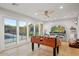 Bright game room features a foosball table, large glass doors to the pool, and a ceiling fan at 1831 E Rovey Ave, Phoenix, AZ 85016