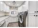 Well-organized laundry room featuring white cabinets, gray countertops, and modern appliances at 1831 E Rovey Ave, Phoenix, AZ 85016