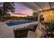 Covered patio overlooking a luxurious pool and outdoor entertaining space at sunset at 1831 E Rovey Ave, Phoenix, AZ 85016