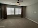A carpeted bedroom featuring large windows with coverings and a ceiling fan at 1840 S Follett Way, Gilbert, AZ 85295