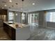 Open concept living space with kitchen island, stainless steel appliances, and sliding doors to the backyard at 1840 S Follett Way, Gilbert, AZ 85295