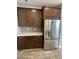 Kitchen area showcasing stainless steel refrigerator and dark wood cabinets with quartz countertop at 1840 S Follett Way, Gilbert, AZ 85295