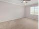 Bright bedroom with carpet floors, a ceiling fan, and a large window at 1848 S Follett Way, Gilbert, AZ 85295