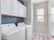 Well-lit laundry room with washer, dryer, cabinets, and wood-look tile flooring at 1848 S Follett Way, Gilbert, AZ 85295