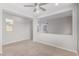 Bright living room with neutral tones, carpet, and a ceiling fan providing a calm and airy atmosphere at 1848 S Follett Way, Gilbert, AZ 85295