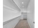 Walk-in closet with shelving, rods, and carpet floors provides ample storage space at 1848 S Follett Way, Gilbert, AZ 85295