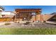 Beautifully landscaped backyard with stone accents, pergola, and a comfortable seating area, perfect for entertaining at 18581 W College Dr, Goodyear, AZ 85395