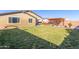 Spacious backyard with lush green grass, mature landscaping, covered patio, and an inviting pergola at 18581 W College Dr, Goodyear, AZ 85395