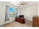 Well-lit bedroom featuring a large window with outside views and a ceiling fan at 18581 W College Dr, Goodyear, AZ 85395