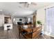 Open-concept dining area with a wooden table and view of the living room and kitchen at 18581 W College Dr, Goodyear, AZ 85395