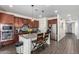 A lovely kitchen features granite counters, dark wood cabinets, an island, and stainless steel appliances at 18581 W College Dr, Goodyear, AZ 85395