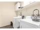 Functional laundry room equipped with a washer, dryer, and overhead storage cabinets at 18581 W College Dr, Goodyear, AZ 85395