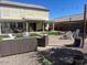 Spacious backyard featuring a covered patio, ample seating, manicured lawn, and charming pavers at 18629 W Fulton St, Goodyear, AZ 85338