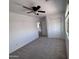 Bedroom featuring carpet flooring, ceiling fan, closet with sliding doors, and view to second floor hallway at 18629 W Fulton St, Goodyear, AZ 85338