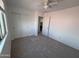 Cozy bedroom features plush carpet, white walls, a ceiling fan, and a closet with sliding doors at 18629 W Fulton St, Goodyear, AZ 85338
