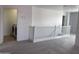 Upstairs hallway with carpet flooring, white railings, and access to laundry room and other areas at 18629 W Fulton St, Goodyear, AZ 85338