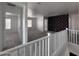 Upstairs hallway with carpet flooring, featuring a decorative wall and views into adjacent rooms at 18629 W Fulton St, Goodyear, AZ 85338