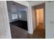Hallway view showing a transition between tiled and wood flooring, and doorways leading to living room and bathroom at 18629 W Fulton St, Goodyear, AZ 85338