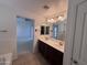 Well-lit bathroom vanity featuring dual sinks, with a view to the main bedroom at 18629 W Fulton St, Goodyear, AZ 85338