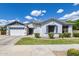 Charming single-story home with a well-manicured lawn and a two-car garage under a beautiful blue sky at 19160 E Canary Way, Queen Creek, AZ 85142