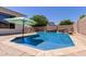 Inviting backyard pool featuring a serene waterfall, a sunshade, and stylish stone coping at 19160 E Canary Way, Queen Creek, AZ 85142