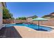 Backyard pool featuring a tranquil waterfall feature, surrounded by a brick patio and block wall at 19160 E Canary Way, Queen Creek, AZ 85142