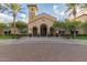 Elegant clubhouse featuring arched entrances, lush landscaping, and a welcoming ambiance for community gatherings at 20283 N 273Rd Ave, Buckeye, AZ 85396
