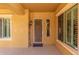 Inviting front porch boasts a security door, shuttered windows, and warm lighting, creating a secure and welcoming entrance at 20283 N 273Rd Ave, Buckeye, AZ 85396