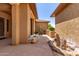 Elegant front porch featuring stucco columns, a decorative door, and a rock garden, creating a welcoming entrance at 20283 N 273Rd Ave, Buckeye, AZ 85396